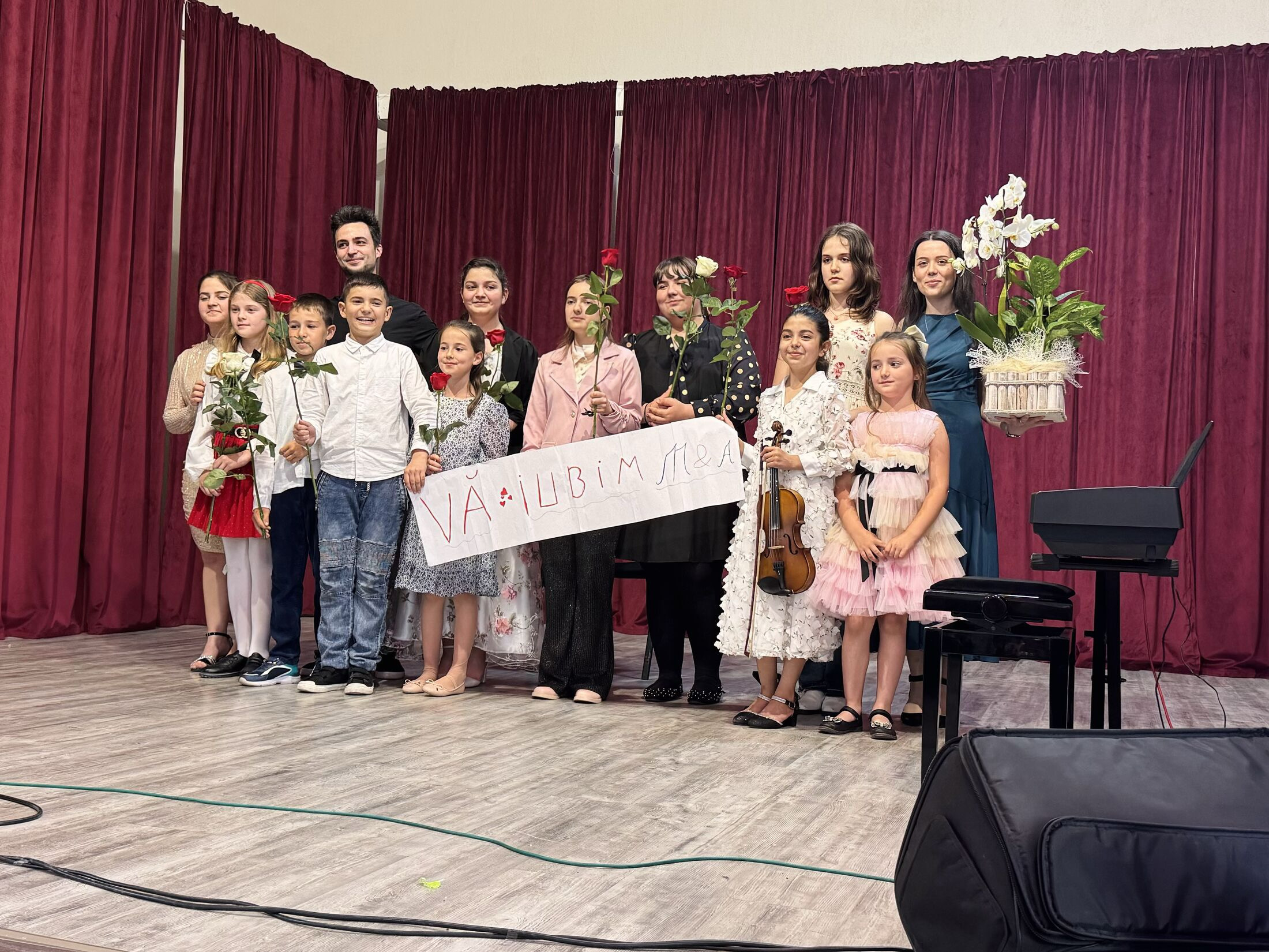 Elevii Academiei de Muzică Secusigiu pe scenă, alături de mesajul „Vă iubim”